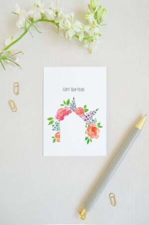 blanco ansichtkaart met op de voorkant de tekst 'happy new home' en huisje van aquarel bloemen. Voor een verhuizing of nieuw huis