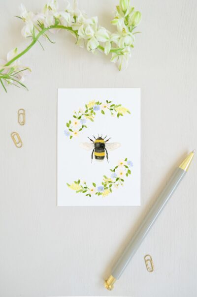 lente ansichtkaart met hommel en bloemenkrans met margrietjes, mimosa en vergeet met nietjes in aquarel