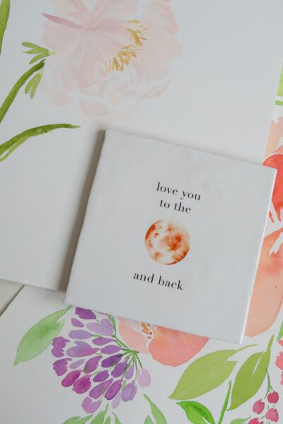 wandtegeltje met aquarel maan in roze en tekst love you to the moon and back